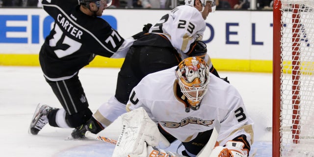 Anaheim Ducks goalie Viktor Fasth, right, blocks a shot by Los Angeles Kings center Jeff Carter(37) with the help of Francois Beauchemin(22) during the second period of an NHL hockey game in Los Angeles, Monday, Feb. 25, 2013. (AP Photo/Chris Carlson)