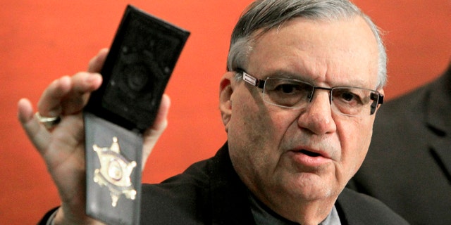 Maricopa County Sheriff Joe Arpaio shows his badge as he holds a ceremony where 92 of his immigration jail officers, who lost their federal power to check whether inmates are in the county illegally, turn in their credentials after federal officials pulled the Sheriff's office immigration enforcement powers Wednesday, Dec. 21, 2011, in Phoenix. The U.S. Department of Homeland Security stripped Sheriff Joe Arpaio's jail officers of their federal powers after federal authorities accused the sheriff's office last week of a wide range of civil rights violations. (AP Photo/Ross D. Franklin)
