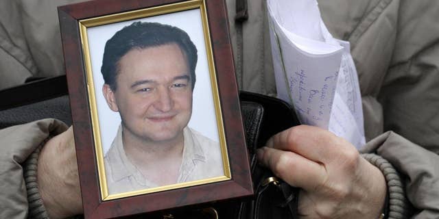 Nataliya Magnitskaya, mother of lawyer Sergei Magnitsky who died in jail two weeks ago, holds a portrait of him and letters he sent to her from jail, as she speaks in central Moscow, Russia, Nov. 30, 2009 (AP)