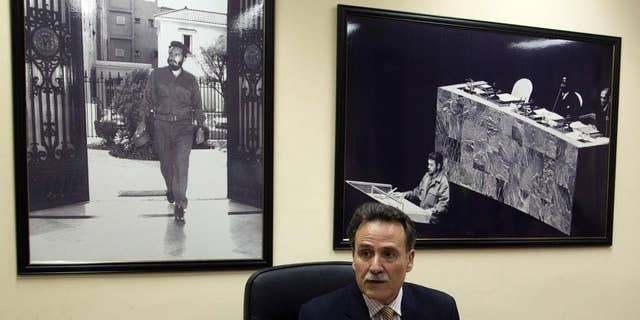 Cuba's Deputy Director of U.S. Affairs Gustavo Machin speaks to reporters at the Foreign Ministry in Havana, Cuba, Wednesday, Sept. 28, 2016, backdropped by framed images of Fidel Castro, left, and Ernesto "Che" Guevara. Machin rejected Donald Trump’s threat to undo detente with Cuba unless it abides by the Republican presidential candidate’s list of demands. (Ismael Francisco, Cubadebate via AP)