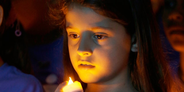 FILE -- April 23, 2014: Melanie Mamondes, 8, participates in a candlelight vigil commemorating National Child Abuse Prevention Month at Jose Marti Park in Miami. Amigos For Kids, a nonprofit organization dedicated to preventing child abuse and neglect, held the event attended by about 200 kids and their families.