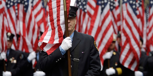 FILE -- March 17, 2015: Firefighters carrying 343 American flags representing each of their colleagues who died during the terrorist attacks on the World Trade Center, march up Fifth Ave. during the St. Patrick's Day Parade.