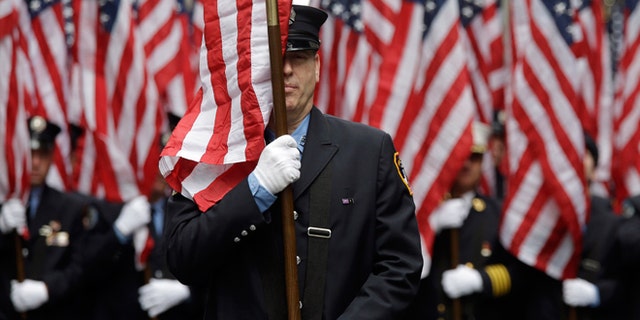 FILE -- March 17, 2015: Firefighters carrying 343 American flags representing each of their colleagues who died during the terrorist attacks on the World Trade Center, march up Fifth Ave. during the St. Patrick's Day Parade.