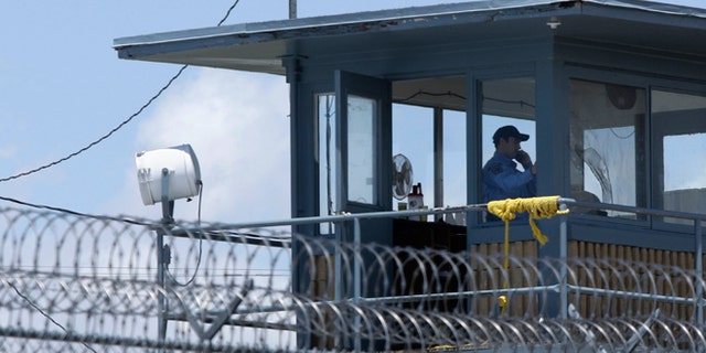 FILE - May 13, 2011: A guard sits in a tower at the Arkansas Department of Correction Tucker Unit near Tucker, Ark. Arkansas Gov. Asa Hutchinson on Feb. 18, 2015, detailed his effort to to reduce the backlog of more than 2,600 state inmates in county jails throughout Arkansas.
