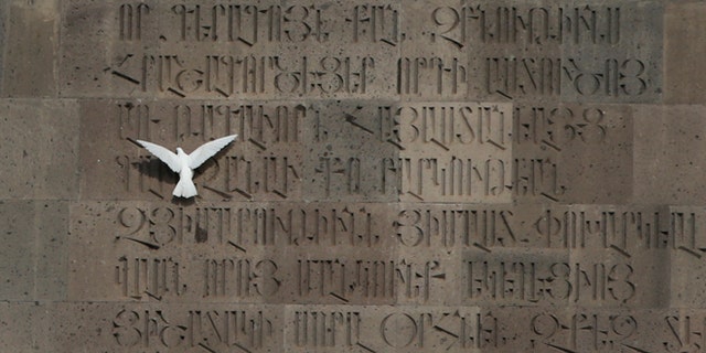 April 23, 2015: A dove tries to sit on a monument wall in Echmiadzin, the religious center of the Armenian Church outside the Armenian capital, Yerevan.