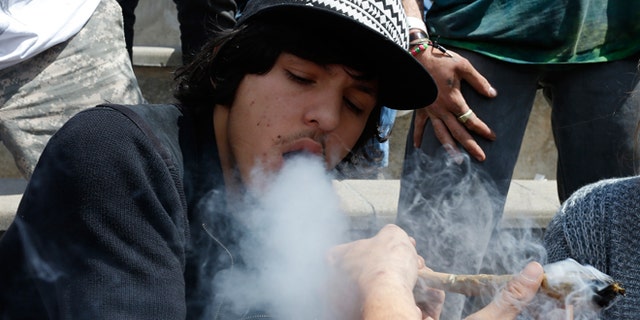 April 18, 2015: Partygoers listen to music and smoke marijuana on one of several days of the annual 4/20 marijuana festival, in Denver's downtown Civic Center Park. The annual event is the second 4/20 marijuana celebration since retail marijuana stores began selling in January 2014.