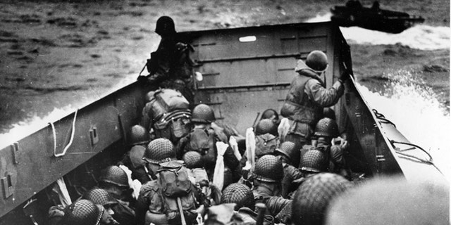FILE - In this June 6, 2014 file photo, allied troops crouch behind the bulwarks of a landing craft as it nears Omaha Beach during a landing in Normandy, France.