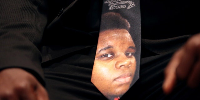 FILE - In this Aug. 25, 2014 photo, a man wears a tie decorated with a picture of Michael Brown during Brown's funeral at Friendly Temple Missionary Baptist Church in St. Louis.