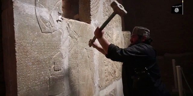 April 11, 2015: In this image made from video posted on a militant social media account affiliated with the Islamic State group purports to show a militant taking a sledgehammer to an Assyrian relief at the site of the ancient Assyrian city of Nimrud, which dates back to the 13th century B.C., near the militant-held city of Mosul, Iraq. The destruction at Nimrud, follows other attacks on antiquity carried out by the group now holding a third of Iraq and neighboring Syria in its self-declared caliphate. The attacks have horrified archaeologists and U.N. Secretary-General Ban Ki-moon, who last month called the destruction at Nimrud "a war crime."