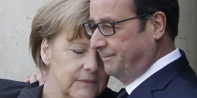 FILE -- Jan. 11, 2015: French President Francois Hollande embraces German Chancellor Angela Merkel, left, as she arrives at the Elysee Palace, Paris. A rally of defiance and sorrow, protected by an unparalleled level of security, on Sunday will honor the 17 victims of three days of bloodshed in Paris that left France on alert for more violence.