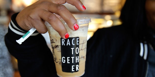 March 18, 2015: Larenda Myres holds an iced coffee drink with a "Race Together" sticker on it at a Starbucks store in Seattle. Starbucks CEO Howard Schultz announced earlier in the day at the company's annual shareholder meeting that participating baristas at stores in the U.S. will be putting the stickers on cups and also writing the words "#RaceTogether" for customers in an effort to raise awareness and discussion of race relations.