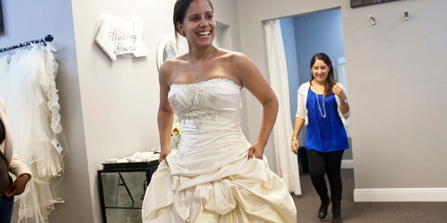 Nov. 13, 2013: Vanessa Gathers of Tampa tries on a dress during the "Operation Wedding Gown" event at The White Closet Bridal in Tampa. Gathers who is in the Air Force and her fiance in the Army will be getting married in December. Military wives who qualified we able to come and receive free wedding dresses. The bride or their spouse had to currently be serving in the military, be currently deployed, have a future deployment or deployed within the last 5 years. The event was a part of the Bride's Across America's campaign, "Operation Wedding Gown". The organization has donated over 10, 000 wedding gowns to military brides.