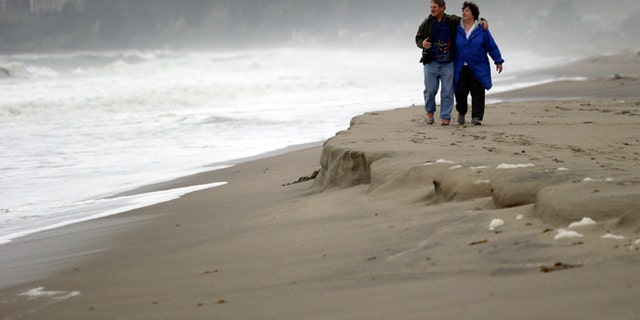 FILE -- Feb. 6, 2015: Ray Matteis, left, and his wife, Penny, walk along the beach at Seacliff State Beach in Aptos, Calif.
