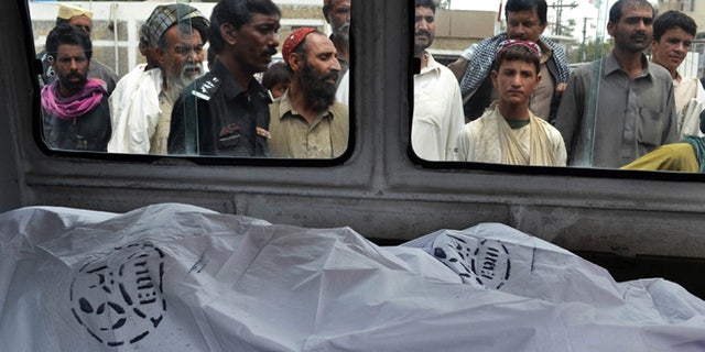 Aug. 6, 2013: People look at the lifeless bodies of victims shot by gunmen at a local hospital in Quetta, Pakistan.