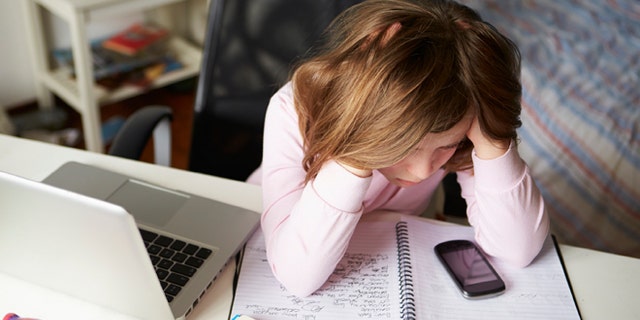 Girl Using Mobile Phone Instead Of Studying In Bedroom