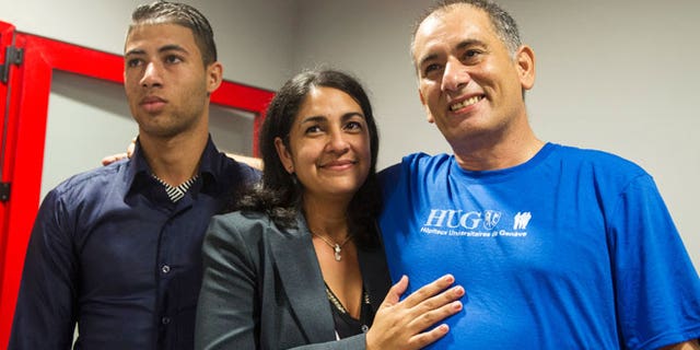 Felix Baez, a member of the International Contingent Brigade "Henry Reeve", who was infected with Ebola in Sierra Leone, poses for a photo with his wife Vania Ferrer and his son Alejandro Baez during a news conference in Havana December 6, 2014.