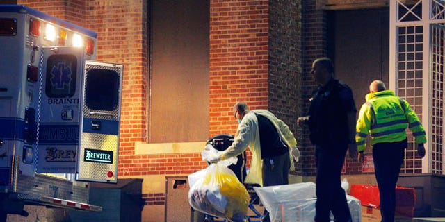 A man collects and bags items behind the ambulance used to transport a patient with possible Ebola symptoms to Beth Israel Deaconess Medical Center in Boston, Massachusetts October 12, 2014. A patient in Massachusetts who recently returned from Liberia and was displaying symptoms of Ebola was transferred from a medical clinic to a Boston hospital on Sunday, the hospital said. The patient has not been confirmed to have the deadly virus. REUTERS/Brian Snyder