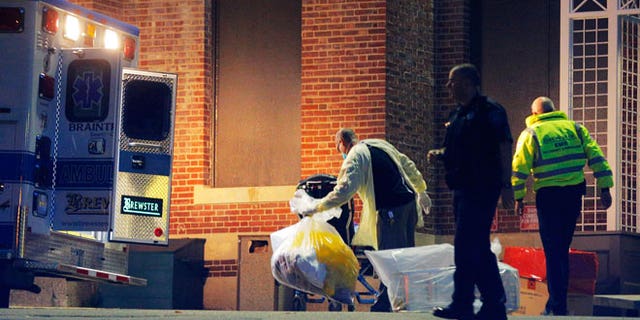 A man collects and bags items behind the ambulance used to transport a patient with possible Ebola symptoms to Beth Israel Deaconess Medical Center in Boston, Massachusetts October 12, 2014. A patient in Massachusetts who recently returned from Liberia and was displaying symptoms of Ebola was transferred from a medical clinic to a Boston hospital on Sunday, the hospital said. The patient has not been confirmed to have the deadly virus. REUTERS/Brian Snyder