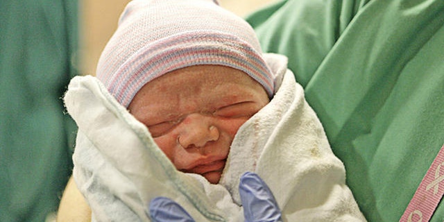 Noah Benton Markham is held by his father Glen Markham just after the birth at St. Tammany Parish Hospital in Covington, La., Tuesday, Jan. 16, 2007. Rebekah Markham was pregnant with an embryo that was rescued from a hospital in the aftermath of Hurricane Katrina. (AP Photo/Alex Brandon)