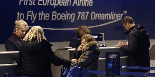 Passengers ticketed to depart on Polish Airlines flight 004 to Warsaw, a Boeing 787, at Chicago's O'Hare International Airport international are rebooked on another airline after the flight was canceled Wednesday, Jan. 16, 2013. The FAA grounded all Boeing 787 Dreamliner airplanes pending safety checks of the planes lithium batteries. (AP Photo/Charles Rex Arbogast)