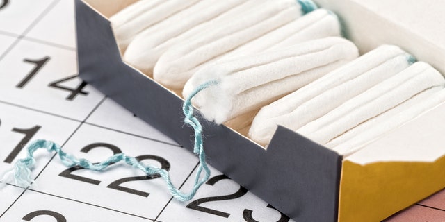 A full box of tampons and a calendar - studio shot