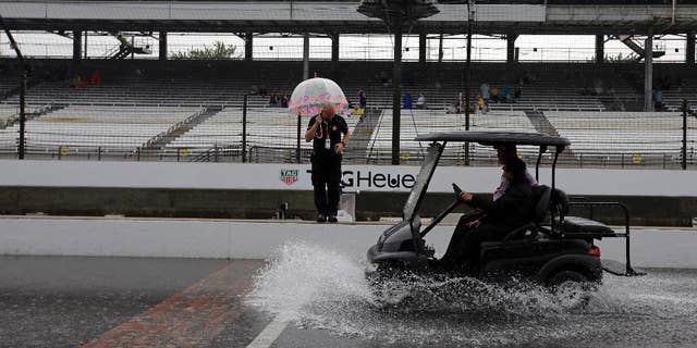 A cart splashes up water as its crosses the start/finish line as rain closed the track on the first day of qualifications for the Indianapolis 500 auto race at Indianapolis Motor Speedway in Indianapolis, Saturday, May 16, 2015. (AP Photo/Darron Cummings)