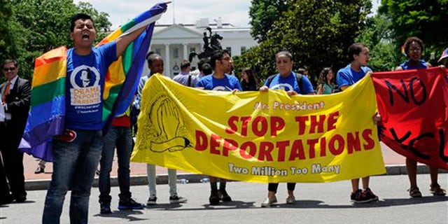 Carlos Padilla of Seattle, left, joins protestors as they block traffic near the White House in Washington, Thursday, June 5, 2014, during an deportation demonstration. In response to President Obamaâs decision to delay the deportation review he ordered from the Department of Homeland Security, United We Dream protested near the White House to highlight the urgency of the administration acting now. (AP Photo/Susan Walsh)