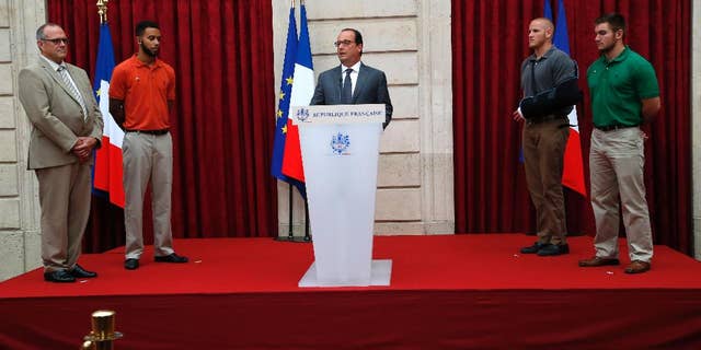 French President Francois Hollande, center, honors, from right, Alek Skarlatos, Spencer Stone, Anthony Sadler and Chris Norman, the three Americans and British businessman who took down a heavily armed man on a passenger train speeding through Belgium, with the French Legion of Honor, Aug. 24, 2015, at the Elysee Palace in Paris.