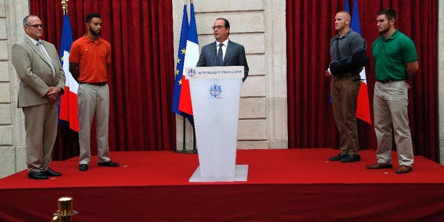 French President Francois Hollande, center, honors, from right, Alek Skarlatos, Spencer Stone, Anthony Sadler and Chris Norman, the three Americans and British businessman who took down a heavily armed man on a passenger train speeding through Belgium, with the French Legion of Honor, Aug. 24, 2015, at the Elysee Palace in Paris.