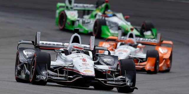 Helio Castroneves, of Brazil, leaves his pit after his first pit stop during the Grand Prix of Indianapolis auto race at Indianapolis Motor Speedway in Indianapolis, Saturday, May 9, 2015. (AP Photo/AJ Mast)