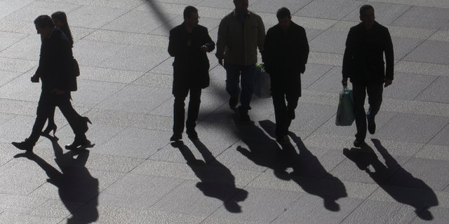 Office workers walk in the business district of Madrid, Tuesday Jan. 15, 2013. Spain has sold an above-target euro 5.8 billion ($7.74 billion) in short-term bills at a sharply reduced interest rate, reflecting easing investor concern over the country's ability to manage its finances without a bailout. Spain's borrowing costs have plunged from unsustainable highs last year after the European Central Bank pledged to help countries by buying up their short-term bonds if they apply for help. Spain says it does not need outside aid for the moment.(AP Photo/Paul White)