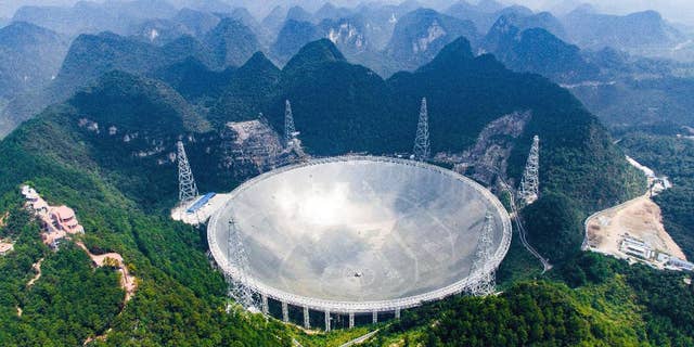 In this Saturday, Sept. 24, 2016 photo released by Xinhua News Agency, an aerial view shows the Five-hundred-meter Aperture Spherical Telescope (FAST) in the remote Pingtang county in southwest China's Guizhou province. China has begun operating the world's largest radio telescope to help search for extraterrestrial life. (Liu Xu/Xinhua via AP)