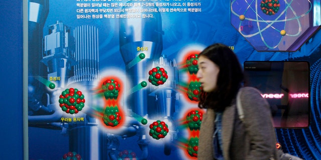 Nov. 30: A South Korean woman walks near a diagram showing the theory of uranium atomic nucleus at the Seoul Science Park.