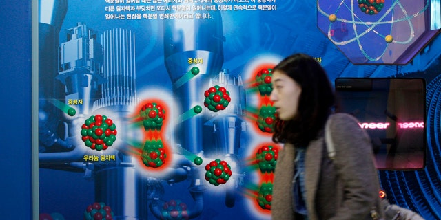 Nov. 30: A South Korean woman walks near a diagram showing the theory of uranium atomic nucleus at the Seoul Science Park.