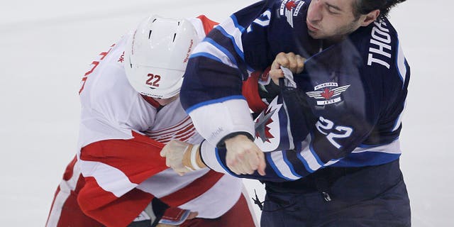 Detroit Red Wings' Jordin Tootoo (22) and Winnipeg Jets' Chris Thorburn (22) scrap during first period NHL action in Winnipeg on Monday, Nov. 4, 2013. (AP Photo/The Canadian Press, John Woods)