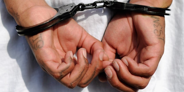 LOS ANGELES, CA - APRIL 29: Handcuffs are seen on the hands of a twenty-year old "Street Villains" gang member who was arrested by Los Angeles Police Department officers from the 77th Street division on April 29, 2012 in Los Angeles, California. The 77th Street division patrol the same neighborhood that truck driver Reginald Denny was nearly beaten to death by a group of black assailants at the intersection of Florence and Normandie Avenues. It?s been 20 years since the verdict was handed down in the Rodney King case that sparked infamous Los Angeles riots. (Photo by Kevork Djansezian/Getty Images)