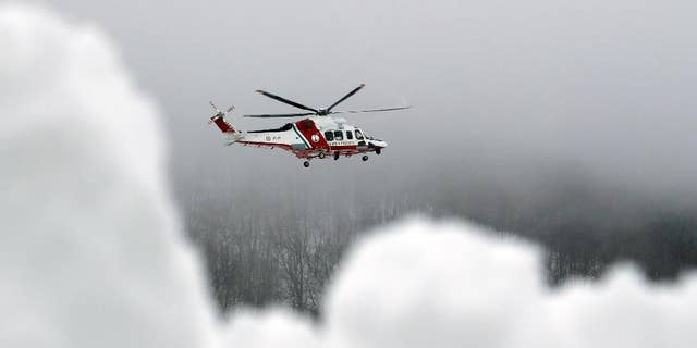 A Coast Guard rescue helicopter flies to the avalanche-hit area where a hotel is buried under the snow, near Farandola, central Italy, Friday, Jan. 20, 2017. Rescue crews located up to eight people alive in the kitchen of an avalanche-crushed hotel on Friday, an incredible discovery that boosted spirits two days after the massive snow slide buried around 30 people in the resort. (AP Photo/Gregorio Borgia)