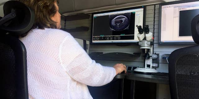 A woman works from a U.S. Bureau of Alcohol, Tobacco, Firearms and Explosives mobile ballistics trailer on Tuesday, May 2, 2017, in Baltimore. The trailer enables detectives to test-fire weapons at the scene of a crime, rather than sending them to a laboratory and waiting days for results.
