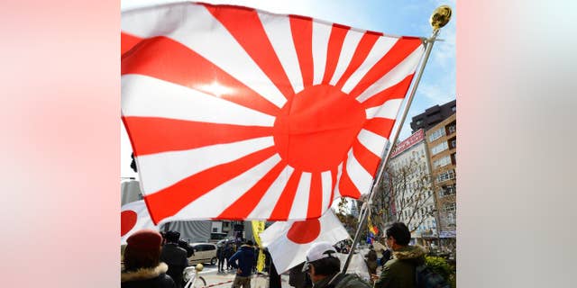Members of a nationalist group hold a "Rising Sun" flag at a rally in Tokyo on February 22, 2013 over the disputed Takeshima/Dokdo islands