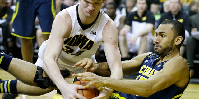 Iowa center Adam Woodbury, left, fights for a loose ball with Michigan forward Jon Horford during the second half of an NCAA college basketball game, Saturday, Feb. 8, 2014, in Iowa City, Iowa. Iowa won 85-67. (AP Photo/Charlie Neibergall)