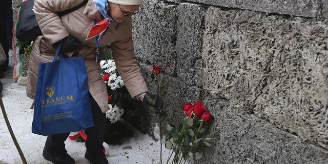 A holocaust survivor commemorate the people killed by the Nazis at the former Auschwitz Germany Nazi death camp in Oswiecim, Poland, Friday, Jan. 27, 2017, on the International Holocaust Remembrance Day that marks the liberation of the Auschwitz Nazi death camp on Jan. 27, 1945. (AP Photo/Czarek Sokolowski)