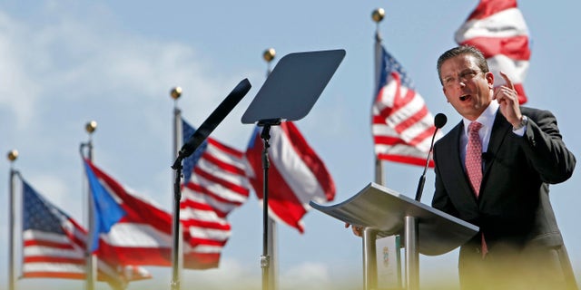 Puerto Rico's newly sworn-in Gov. Alejandro Garcia Padilla delivers his inaugural speech during an outdoor ceremony at the Capitol building in San Juan, Puerto Rico, Wednesday, Jan. 2, 2013. Garcia is a 41-year-old attorney and former local senator who narrowly defeated pro-statehood Gov. Luis Fortuno was sworn in on a stage overlooking the Atlantic Ocean amid the cheers of thousands of supporters from his party, which opposes statehood. (AP Photo/Ricardo Arduengo)