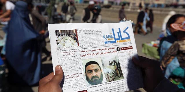 FILE - In this May 25, 2016, file photo, an Afghan man reads a local newspaper with photos the former leader of the Afghan Taliban, Mullah Akhtar Mansoor, who was killed in a U.S. drone strike in Kabul, Afghanistan. A senior U.S. defense official says the administration is moving toward a decision to expand the military's authority to conduct airstrikes against the Taliban in Afghanistan. The official says a final decision has not been made. But there is a broad desire to give the military greater ability to help the Afghan forces. (AP Photo/Rahmat Gul, File)