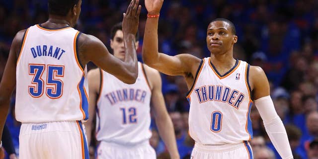 Oklahoma City Thunder guard Russell Westbrook (0) high-fives teammate Kevin Durant (35) in the first quarter of Game 7 of an opening-round NBA basketball playoff series against the Memphis Grizzlies in Oklahoma City, Saturday, May 3, 2014. (AP Photo/Sue Ogrocki)