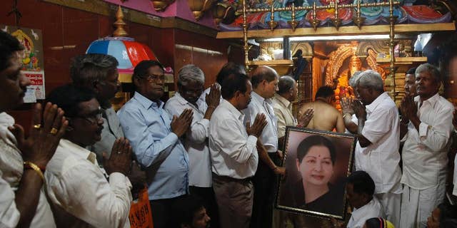 Supporters of Indian southern state of Tamil Nadu Chief Minister Jayalalithaa hold her photograph as they pray for her health at a temple in Mumbai, India, Monday, Dec. 5, 2016. Thousands of Jayalalitha supporters and well wishers across India prayed for her speedy recovery after she was readmitted to the hospital in Cheanni following a cardiac arrest on Sunday evening. (AP Photo/Rafiq Maqbool)
