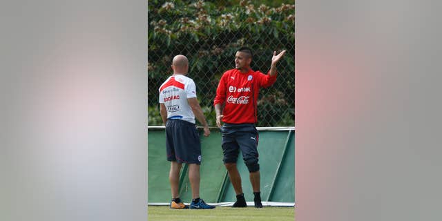 Chile's Arturo Vidal, right, talks with head coach Jorge Sampaoli during a training session at Toca da Raposa 2 center in Belo Horizonte, Brazil, Thursday, June 19, 2014. Chile plays in group B of the 2014 soccer World Cup. (AP Photo/Victor R. Caivano)