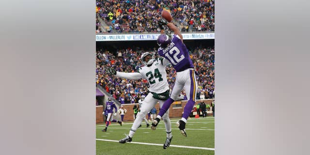 New York Jets cornerback Phillip Adams, left, breaks up a pass in the end zone intended for Minnesota Vikings wide receiver Charles Johnson (12) during the second half of an NFL football game, Sunday, Dec. 7, 2014, in Minneapolis. (AP Photo/Alex Brandon)