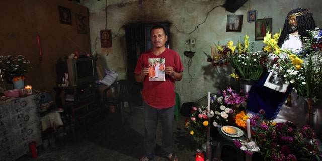 Clemente Rodriguez holds a photo of his missing son Christian Rodriguez Telumbre in his home in Tixtla, Mexico.