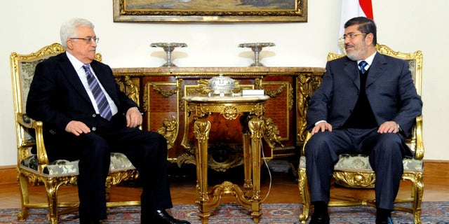 In this image released by the Egyptian Presidency, Egyptian President Mohammed Morsi, right, meets with Palestinian President Mahmoud Abbas at the Presidential Palace in Cairo, Egypt, Wednesday, Jan. 9, 2013. (AP Photo/Egyptian Presidency)