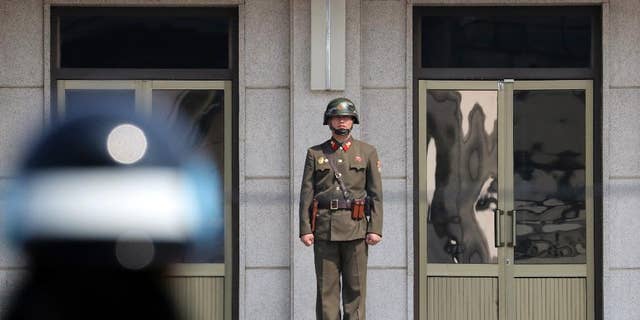 A North Korean soldier looks at the south side as a South Korean soldier stands guard before U.S. Secretary of State Rex Tillerson arrives at the border village of Panmunjom, which has separated the two Koreas since the Korean War.